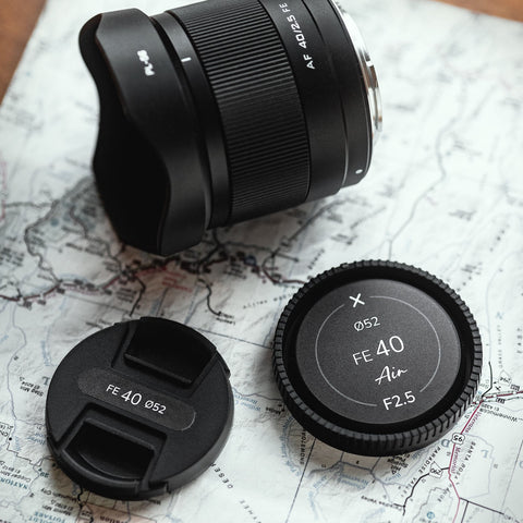 Viltrox Camera lens cap on a map background featuring Field Made Co lens indicator sticker labels.